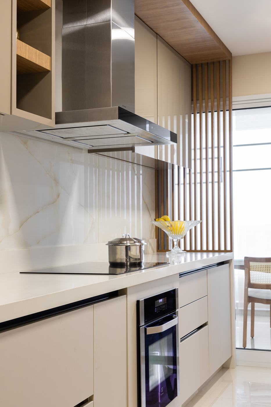 Cozinha off-white com coifa inox, forro e divisória ripada em madeira
