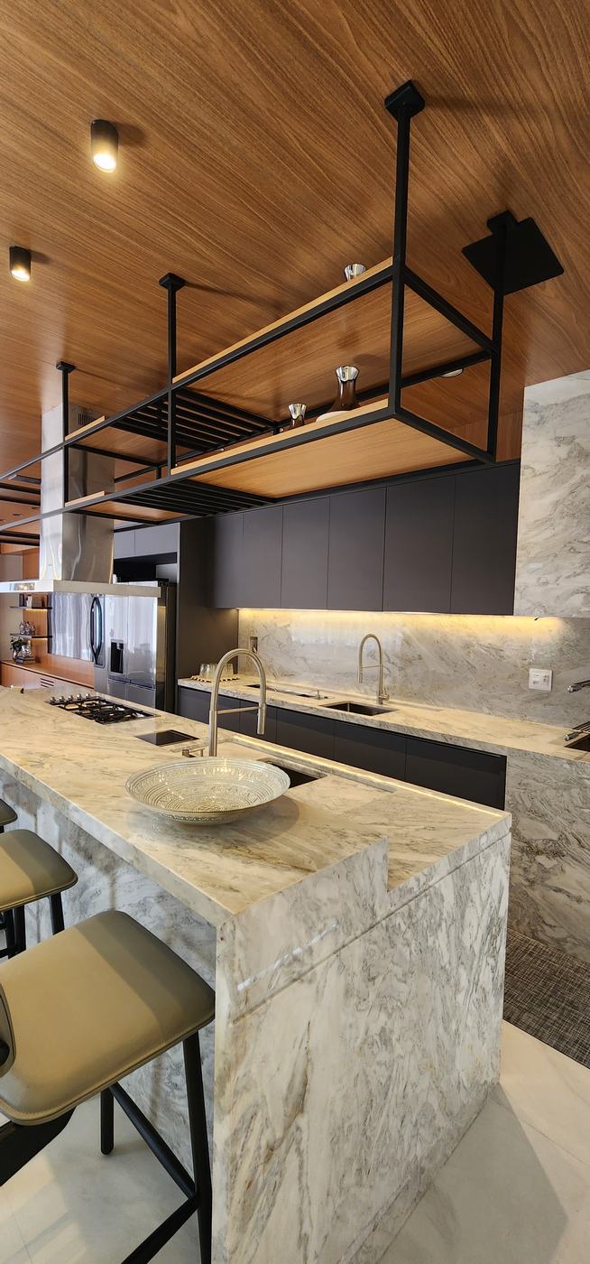 Ilha em mármore com cascata, prateleira suspensa de metal e madeira e marcenaria preta